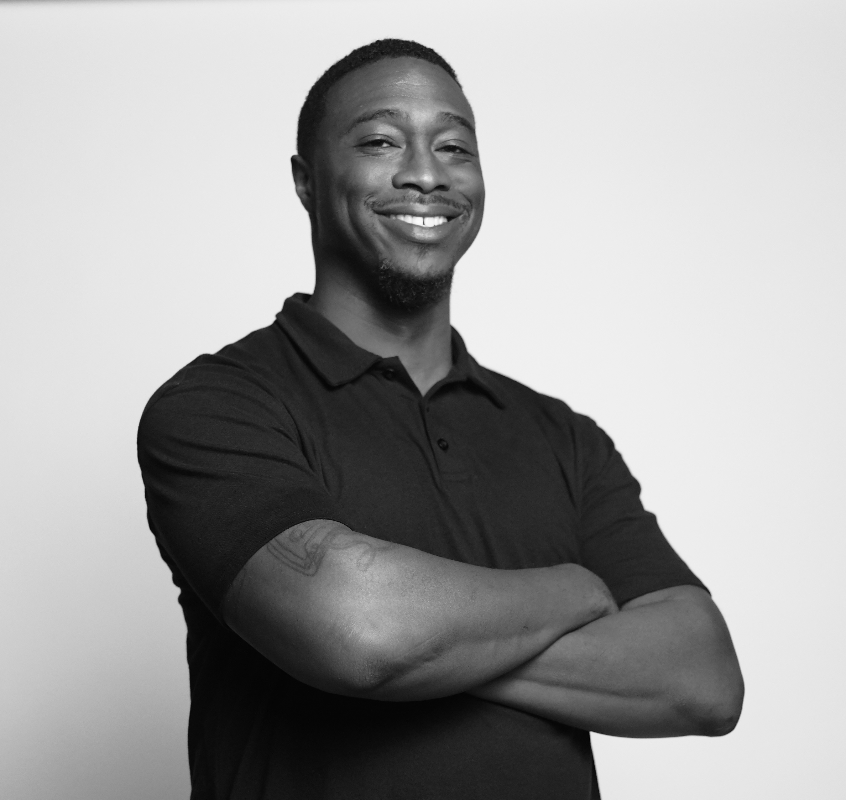 Brian Anderson smiling, with his arms folded.